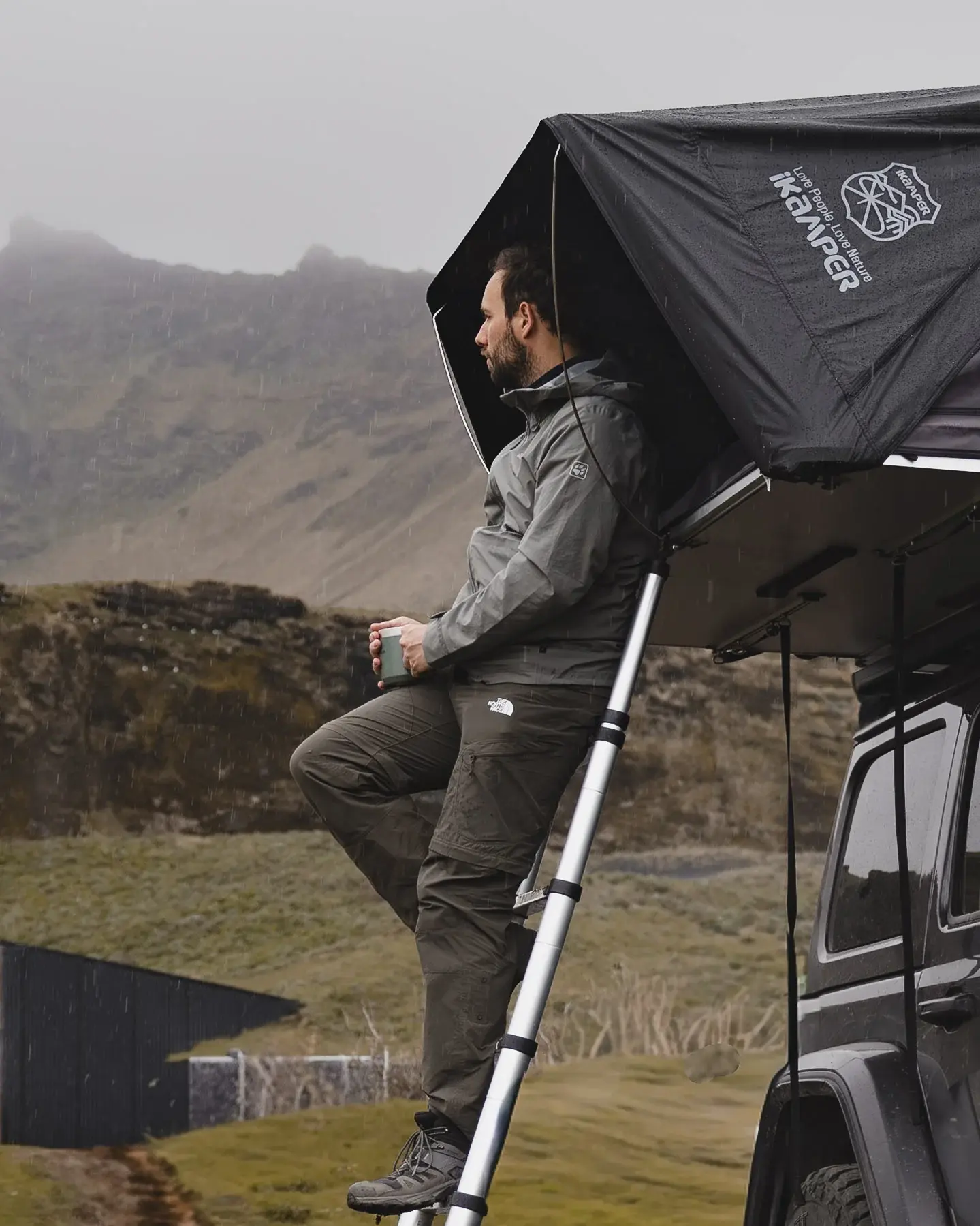Bjorn looking out of a rooftop tent on a Jeep